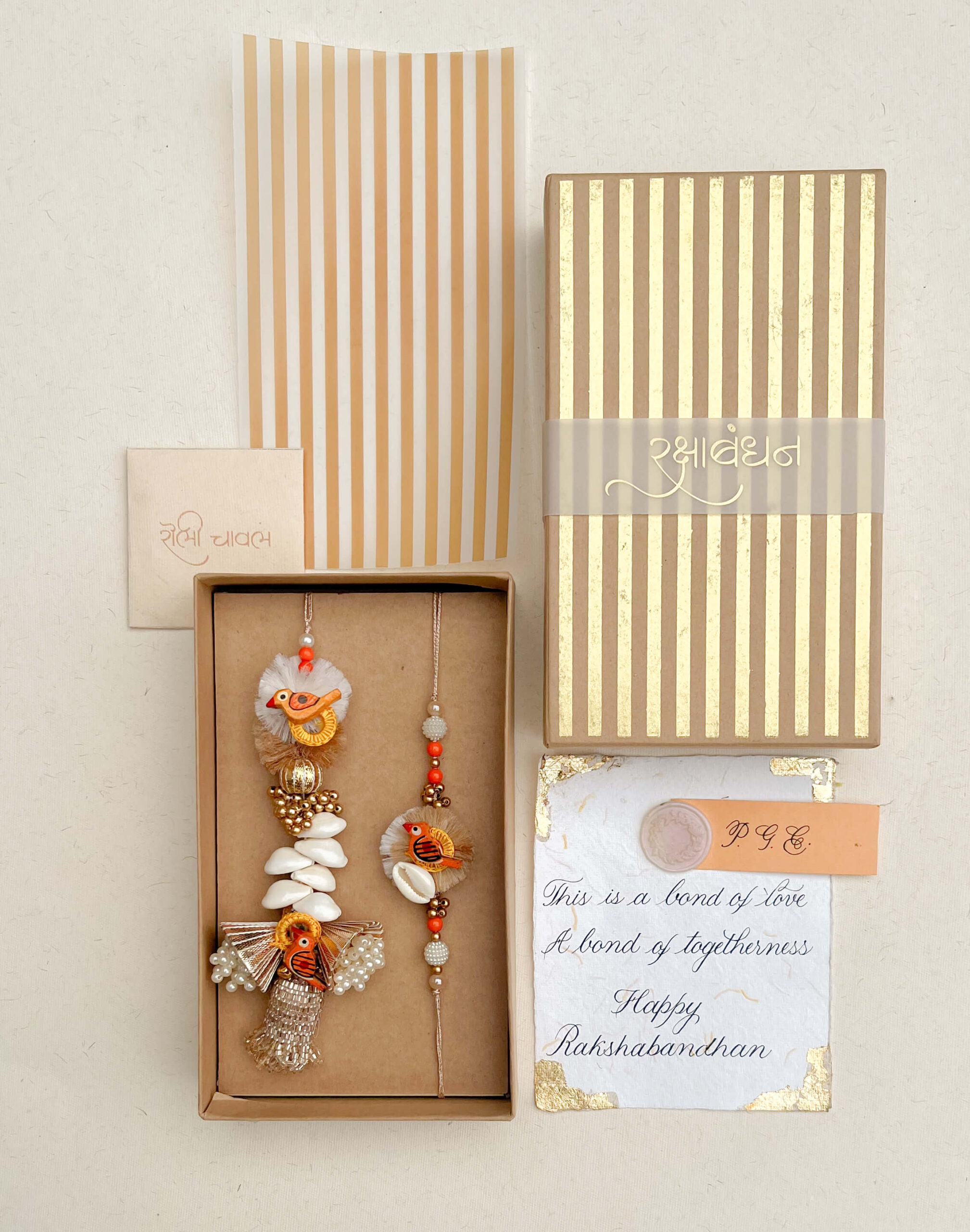 Sparrow Rakhi Lumba and Roli Chawal Gift Set in Gold Striped Box by Pandora Gift Co for Rakshabandhan